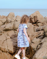 Girl wearing Organic Cotton Dress in blue looking away