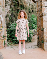 Standing Girl wearing Organic Cotton Dress in Beige with Animal Print