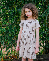 Girl Wearing Organic Cotton Dress in Beige with Animal Print