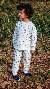 Boy wearing white unisex organic cotton kid's sweatshirt and joggers with bee animal print