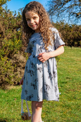 Girl wearing grey organic cotton dress with elephant animal pattern