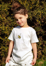 Girl wearing white unisex organic cotton kid's T shirt with bee animal print