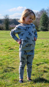 Smiling girl wearing grey unisex organic cotton kid's T shirt and joggers with elephant animal print outdoors