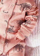 close up of unisex pink organic cotton bodysuit romper with leopard animal print