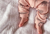 close up of unisex pink organic cotton onesie with leopard animal print