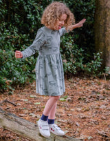 Girl wearing organic cotton olive green dress with animal print in outdoors