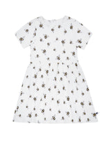 Flatlay of organic cotton girl's dress in white with bee animal print