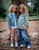 girl wearing salmon pink organic cotton unisex joggers with giraffe design